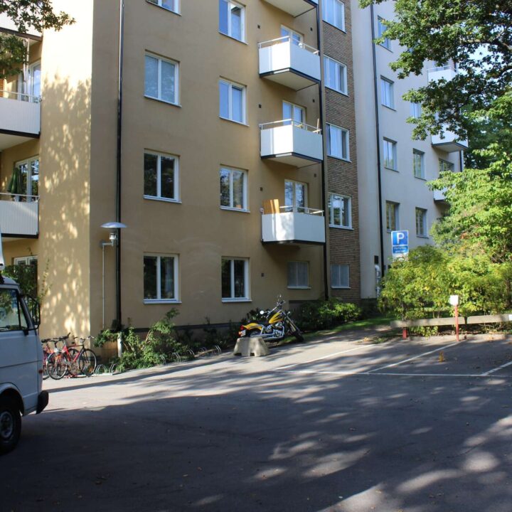 Husfasad med balkonger och träd utanför