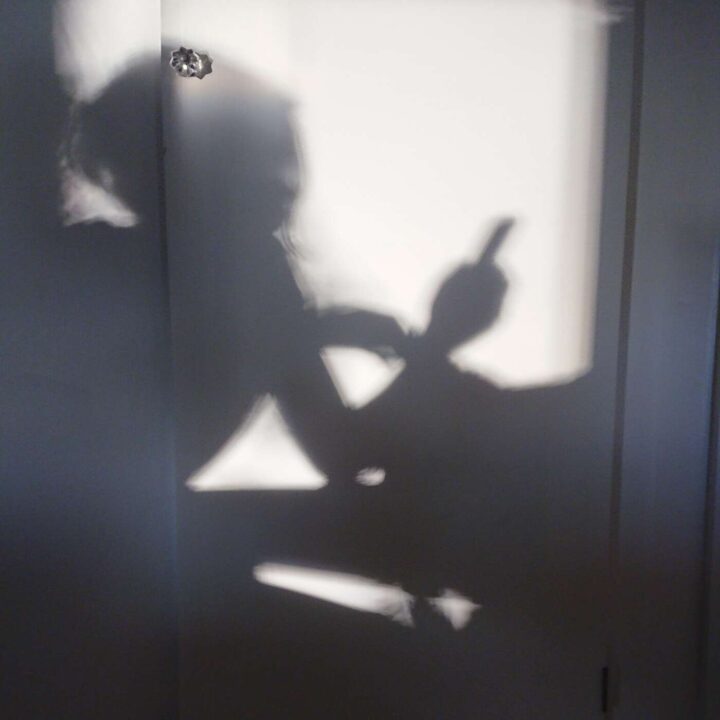 En skugga av person som håller i en mobil