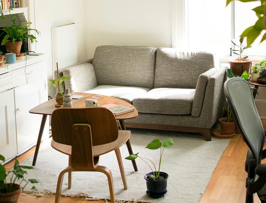 andrahandsuthyrning-vit-soffa-i-vardagsrum.med-vaxter-och-vit-inredning